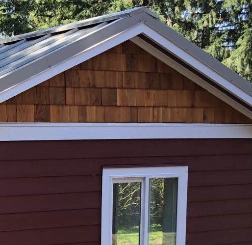 Cedar-shake gable over red lap siding