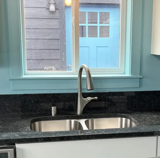 Countertop-matching backsplash behind a sink