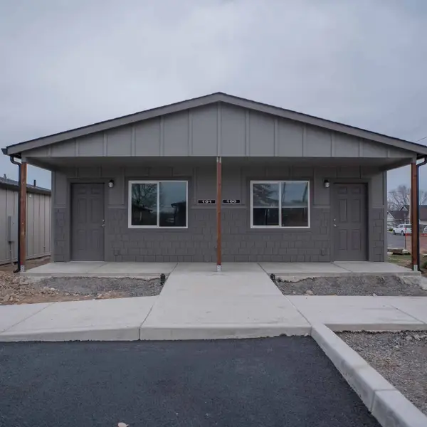 Finished gray duplex with a full-width covered porch and two front doors