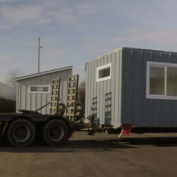 White Wolf truck hitched to a trailer carrying a long gray home