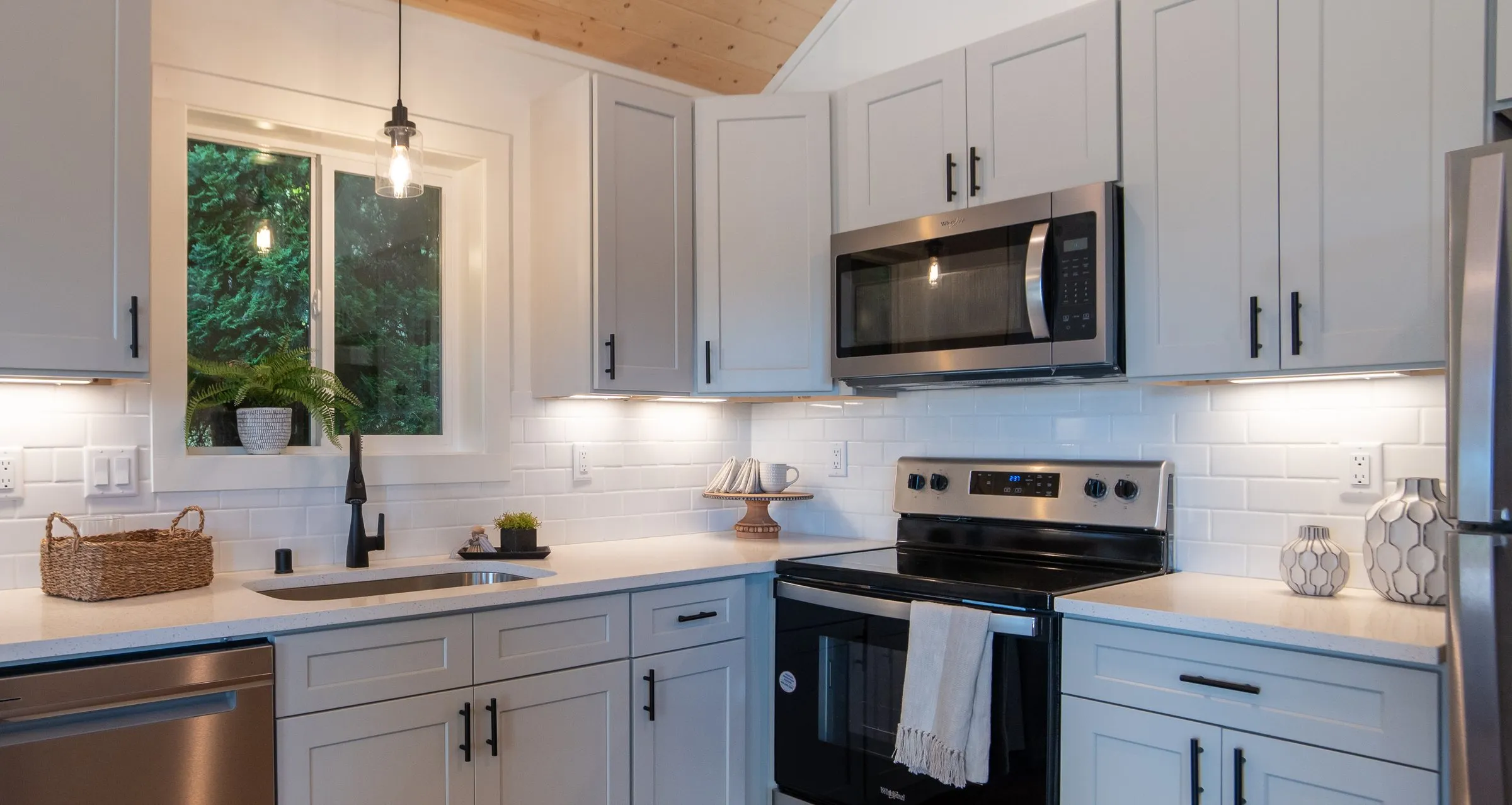 Model F kitchen with stainless appliances and a full-height tile backsplash