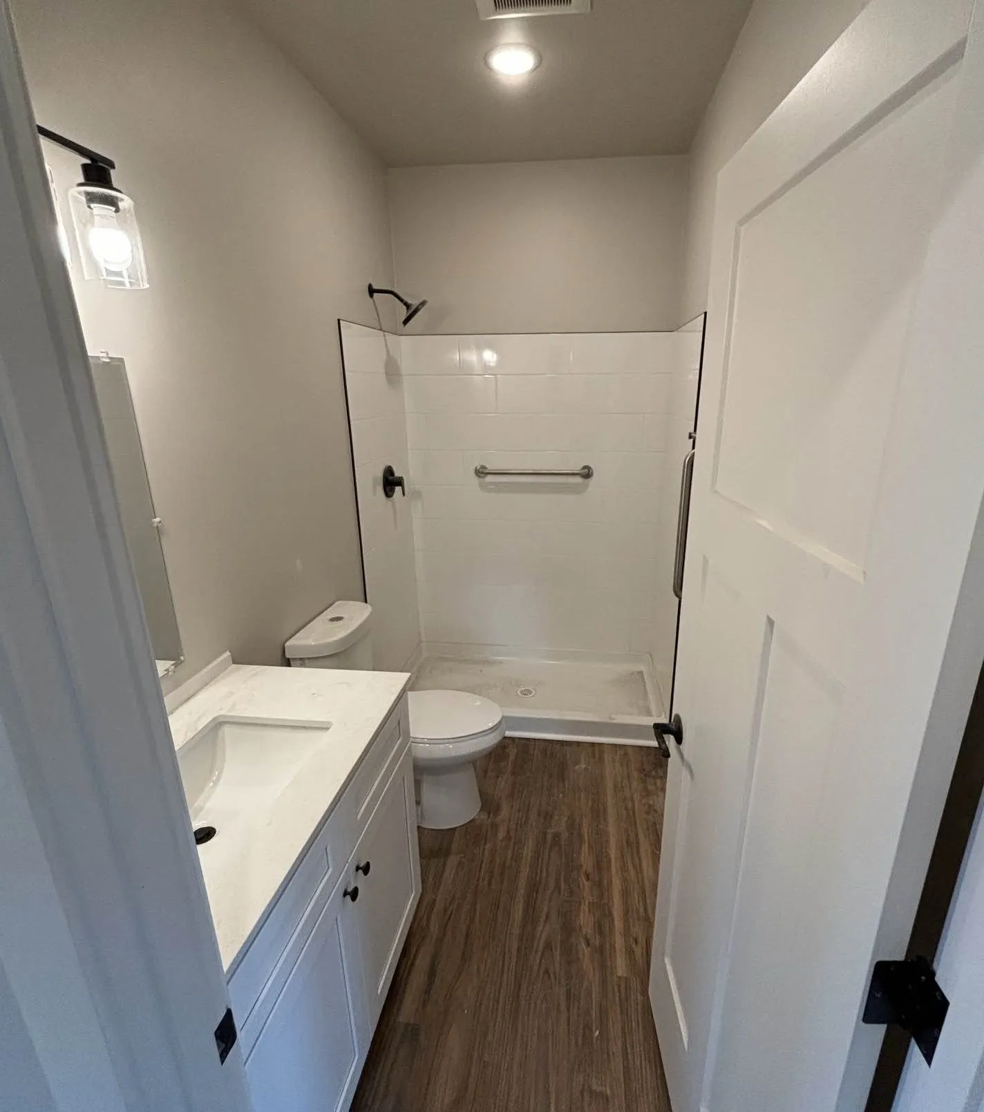 Wolf bathroom with a white vanity, black hardware, and a tile shower