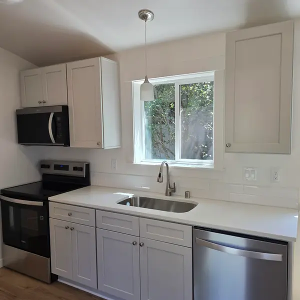 Kitchen sink wall with gray cabinets, subway tile, and a black range in a Wolf Model B