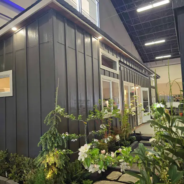 Dark charcoal Wolf Model E on display indoors, with a planted path at the entry