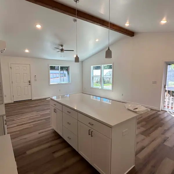 White kitchen island in an open living area under a wood beam in a Wolf Model I