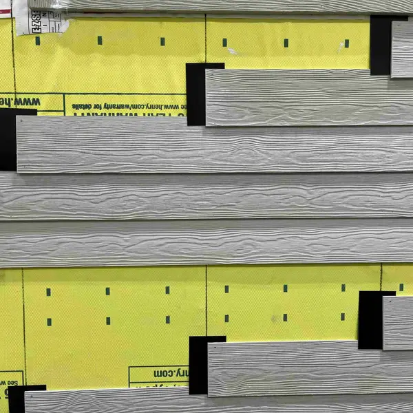 Lap siding going on over yellow weather barrier