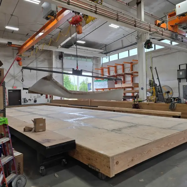 A floor being built on the factory line under an overhead crane