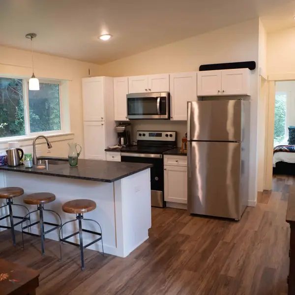 Kitchen with a dark stone island and white cabinets in a Wolf Model E