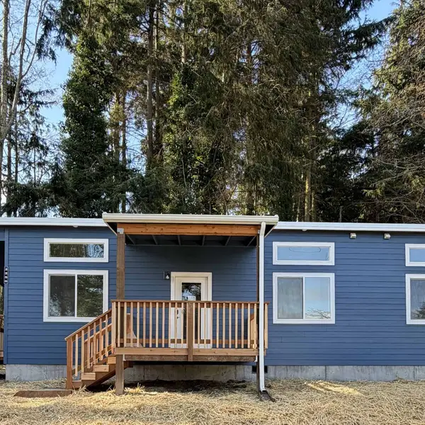 Blue Wolf Model F with a wood front porch and side deck among the trees