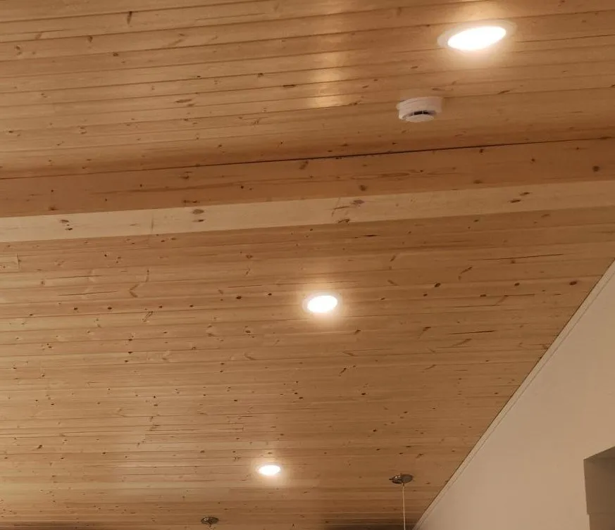 Pine-wrapped ridge beam under a pine ceiling