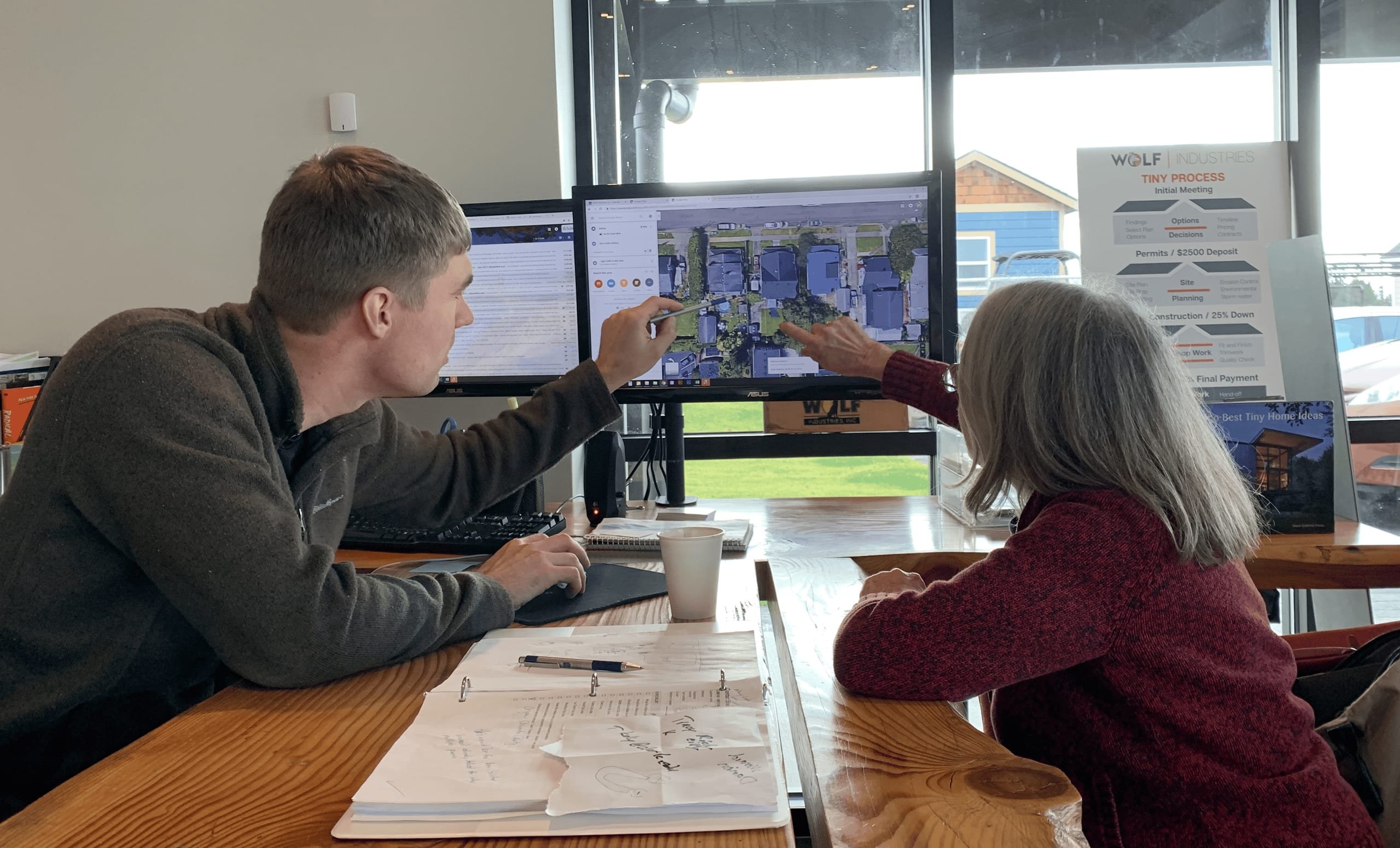 A Wolf team member and customers reviewing a property plan together.