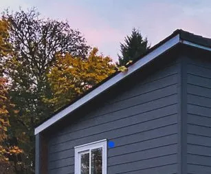 Shed-roof Wolf home in dark blue siding