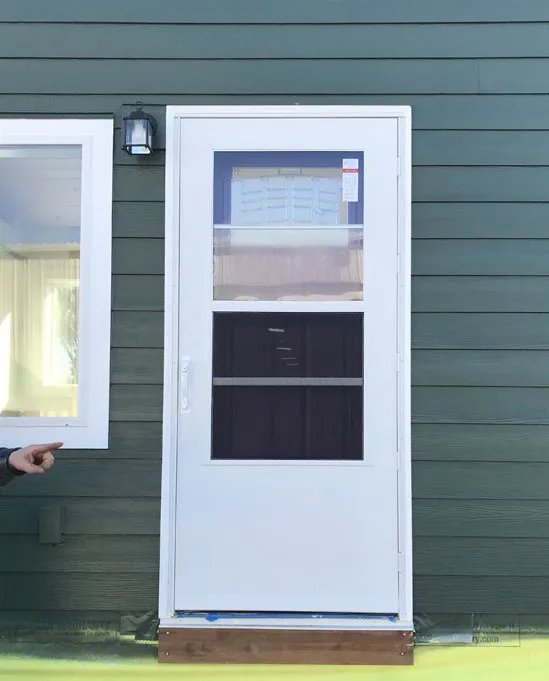 White storm door on a green Wolf home