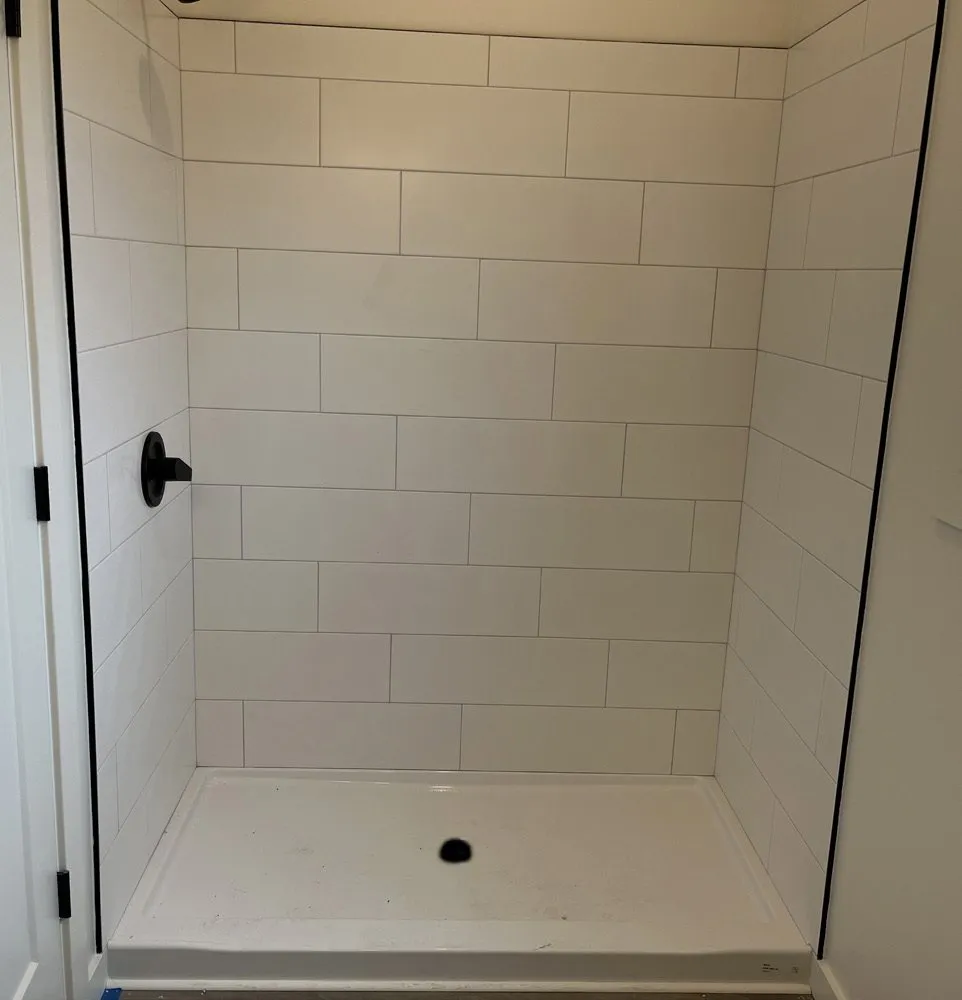 White tile shower with an acrylic base