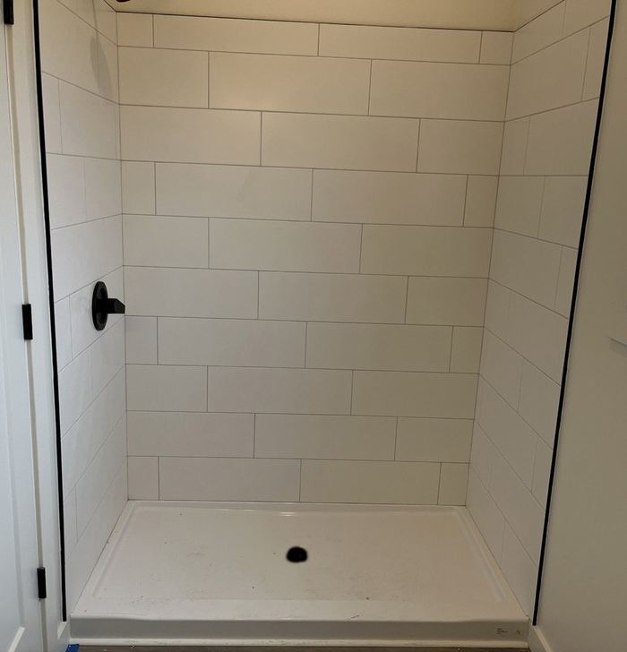 White tile shower with an acrylic base