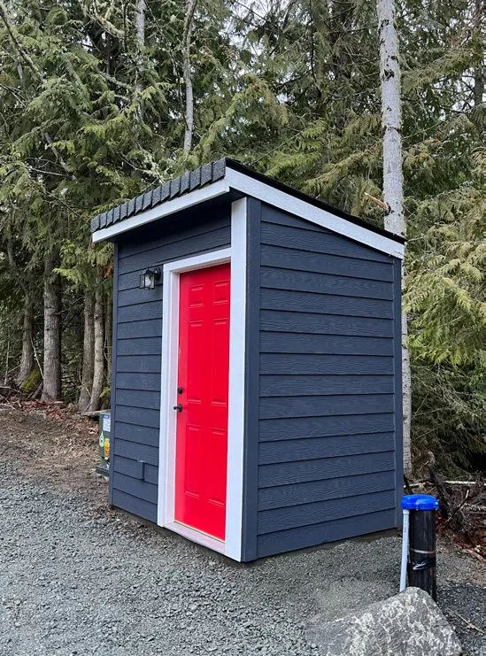 Small well pump house with a red door