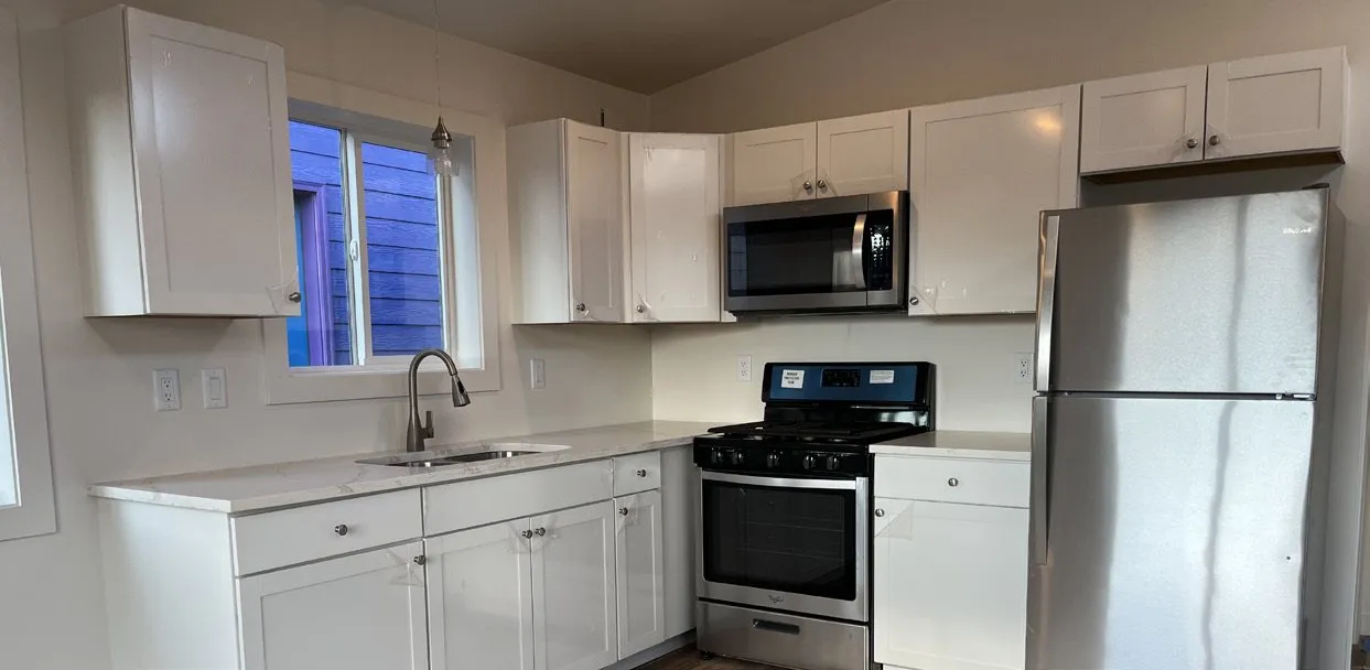 L-shaped white Shaker kitchen with stainless appliances
