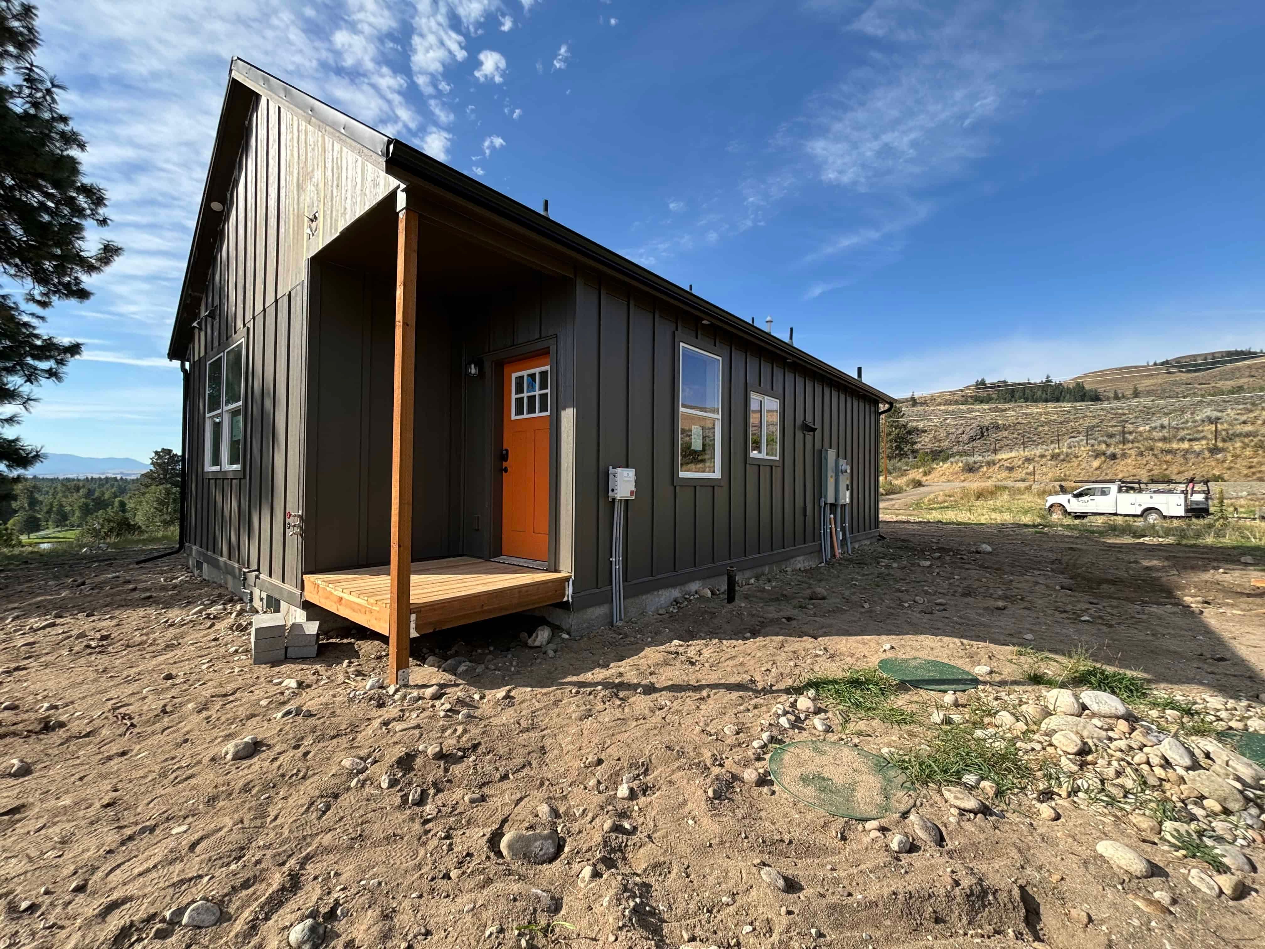 Wolf Home, a Model J modular home with an orange front door and cedar porch in Winthrop, Washington