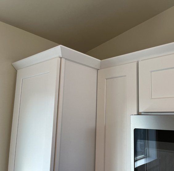 White upper cabinets with crown molding