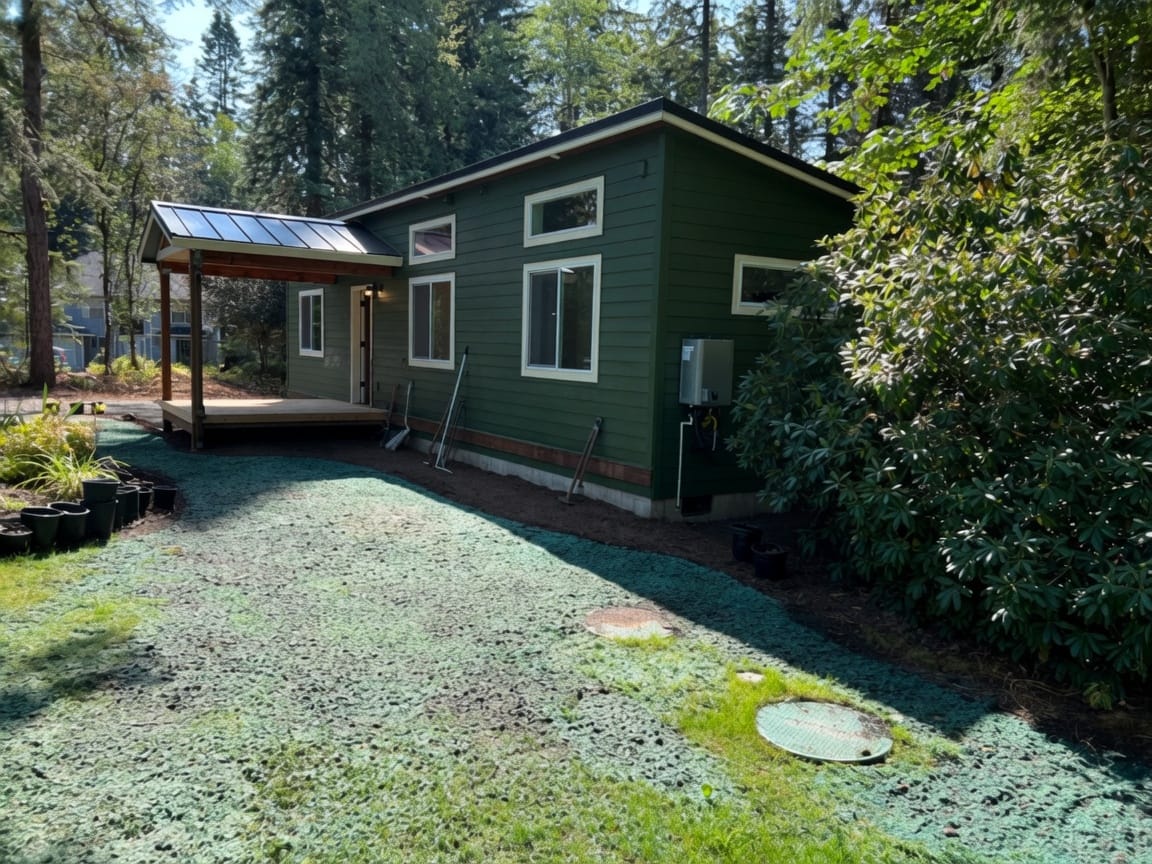 Green and white Wolf Model E home with a covered front porch deck.
