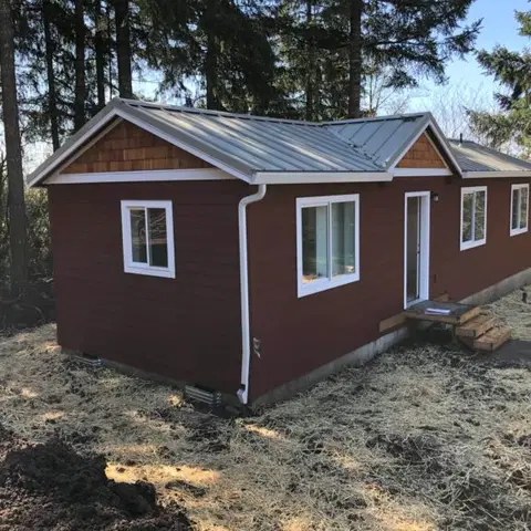 Red and white Wolf Model E home with cedar shake gables.
