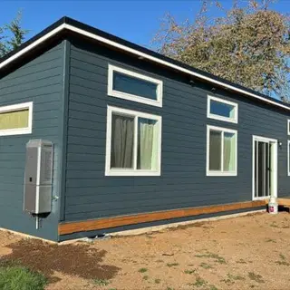 Slate blue-gray Wolf Model E home with white trim and a sliding door.