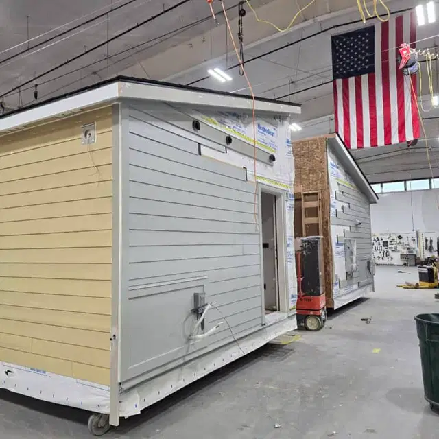Wolf Model L module with partial siding and housewrap still on, inside the shop.