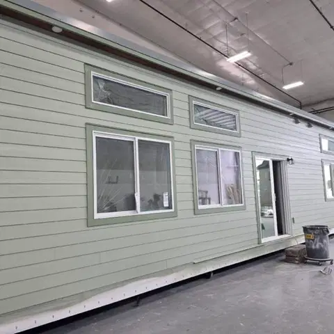 Sage green Wolf Model E module with transom windows inside the factory.