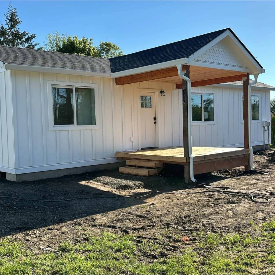 All-white Wolf Model E home with covered front deck porch.