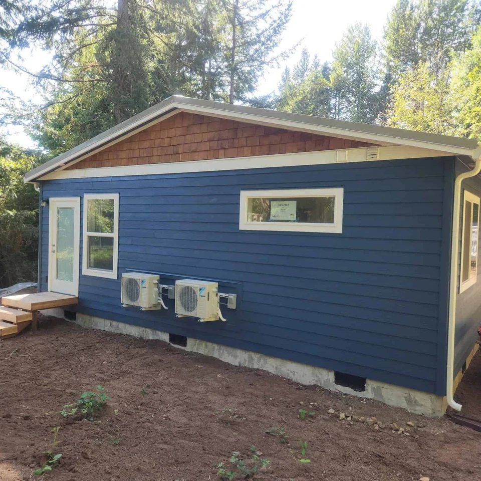 Wolf Model E home with blue paint, white trim, and cedar shake gables.