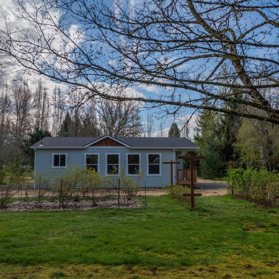 Wolf Model L home next to blueberry and flower garden.