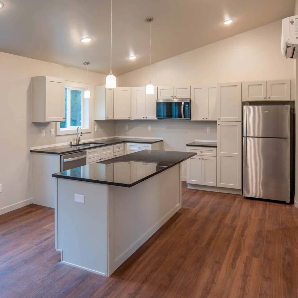 Island kitchen with black quartz countertops in a Wolf Model L home.