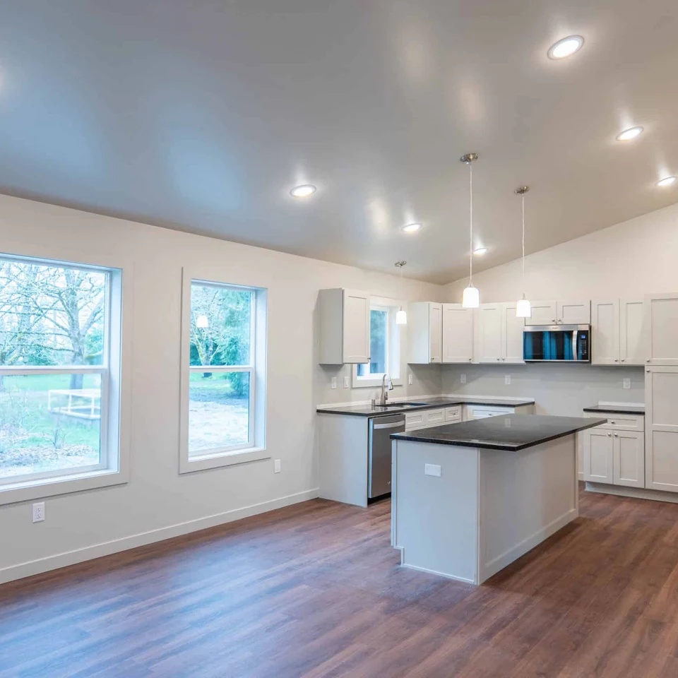 Island kitchen with black quartz countertops in a Wolf Model L home.