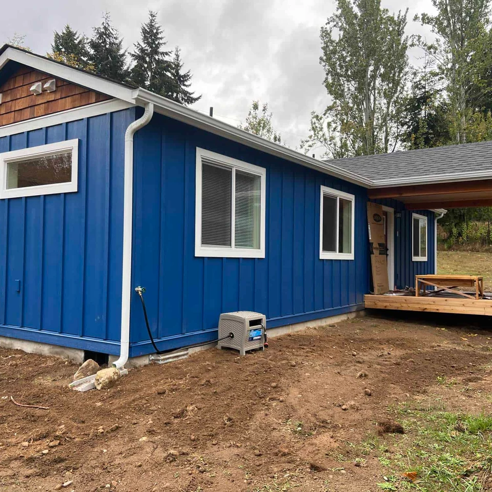 Blue and white Wolf Model F home with covered porch deck and cedar shake gables.