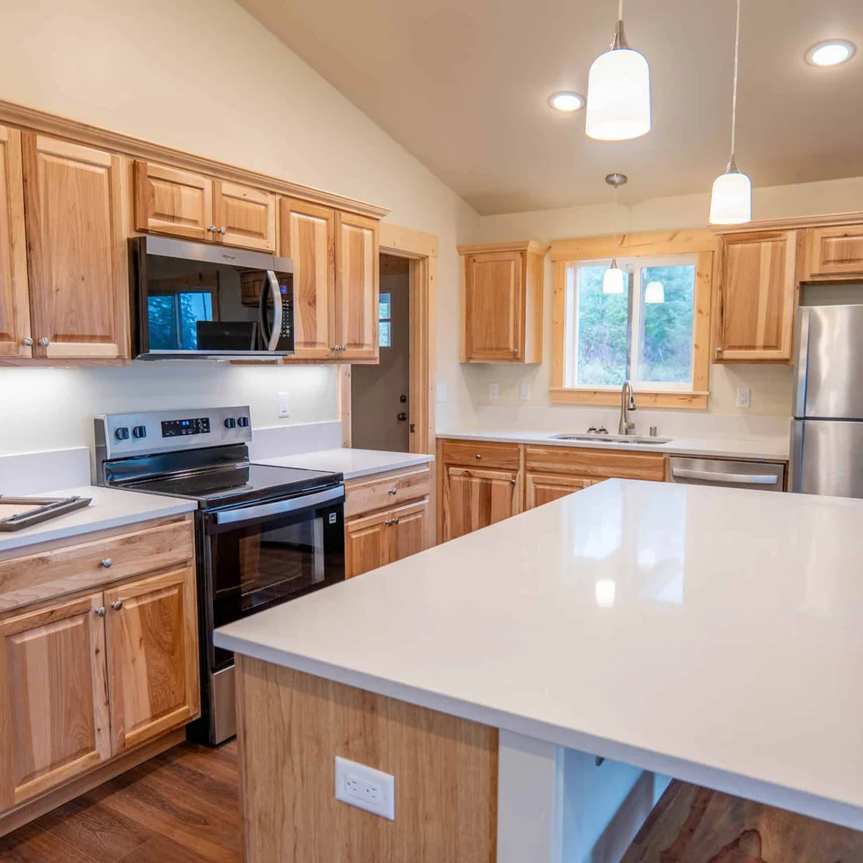 L-Shaped Island Kitchen in a Wolf Model I home with detailed trim and undermount sink.
