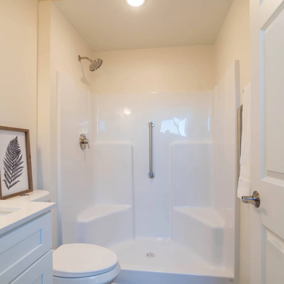 Shower with grab bars and low step entry in a Wolf Model K home.