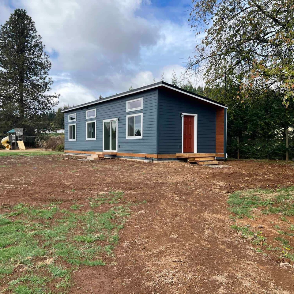 Green and white Wolf Model E home with red door.