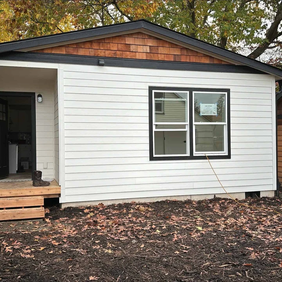 White and black Wolf Model J home with cedar shake gables.