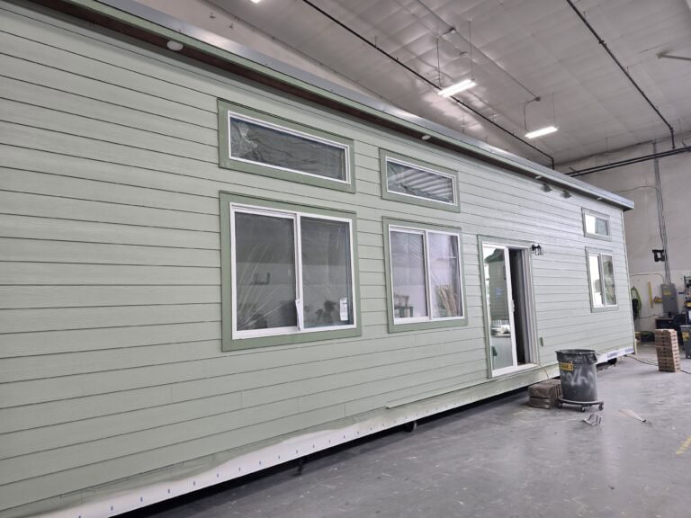 Sage green Wolf Model E module with transom windows inside the factory.