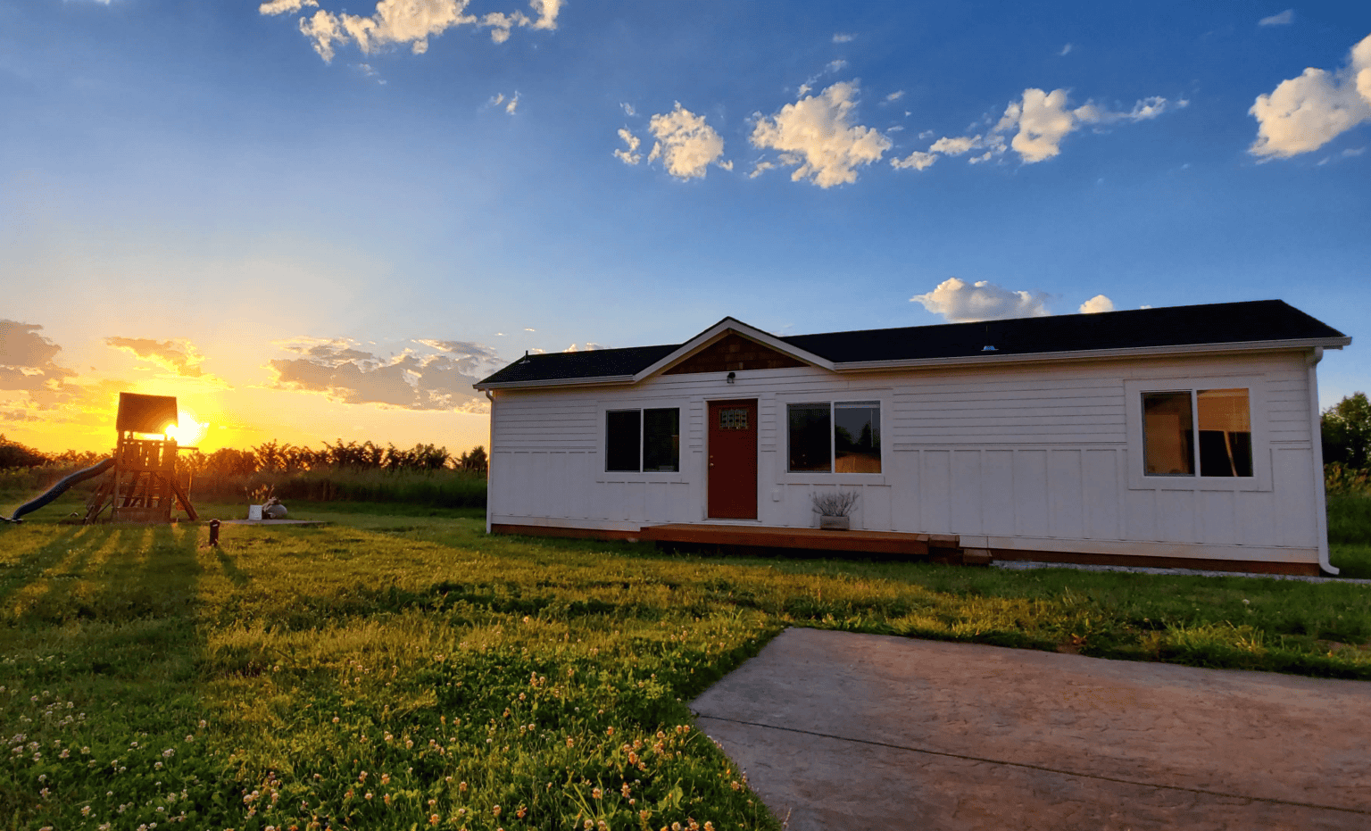 White Wolf Model E home with cedar shake gable at sunset.