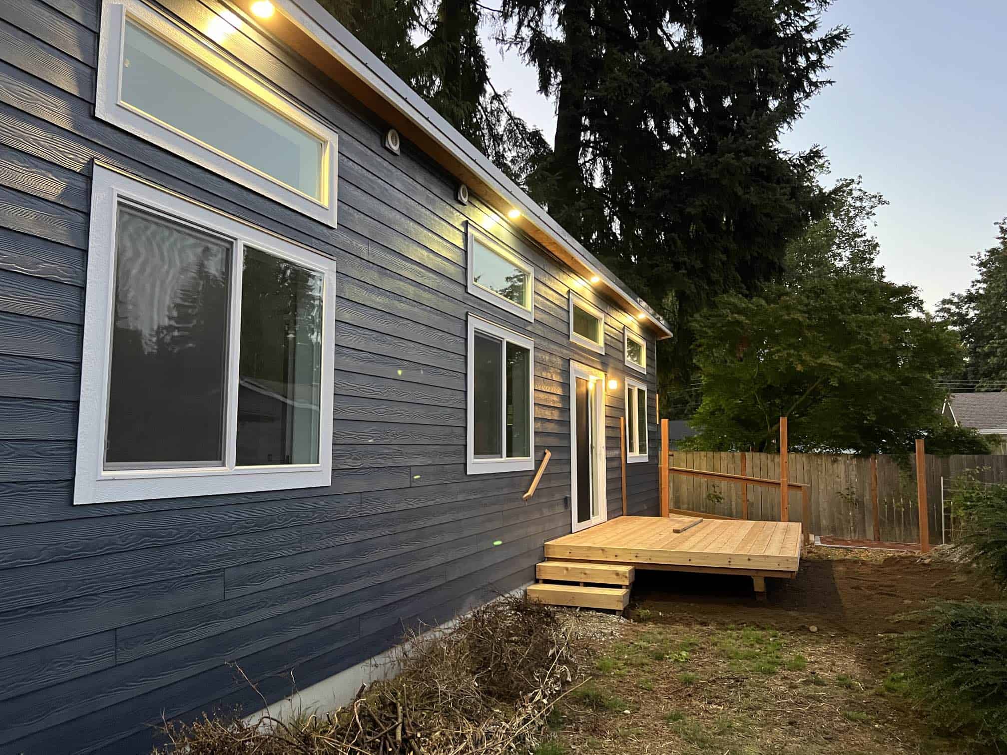 Blue Model E Wolf home with transom windows and exterior soffit lighting.