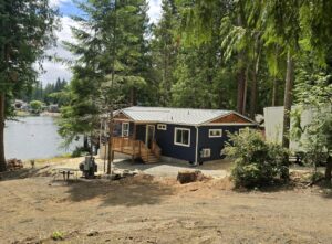 Blue and white Wolf Model I home with covered deck patio and view of Puget Sound.