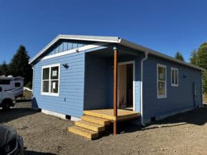 Model J Wolf home that is blue with white trim and has a metal roof.