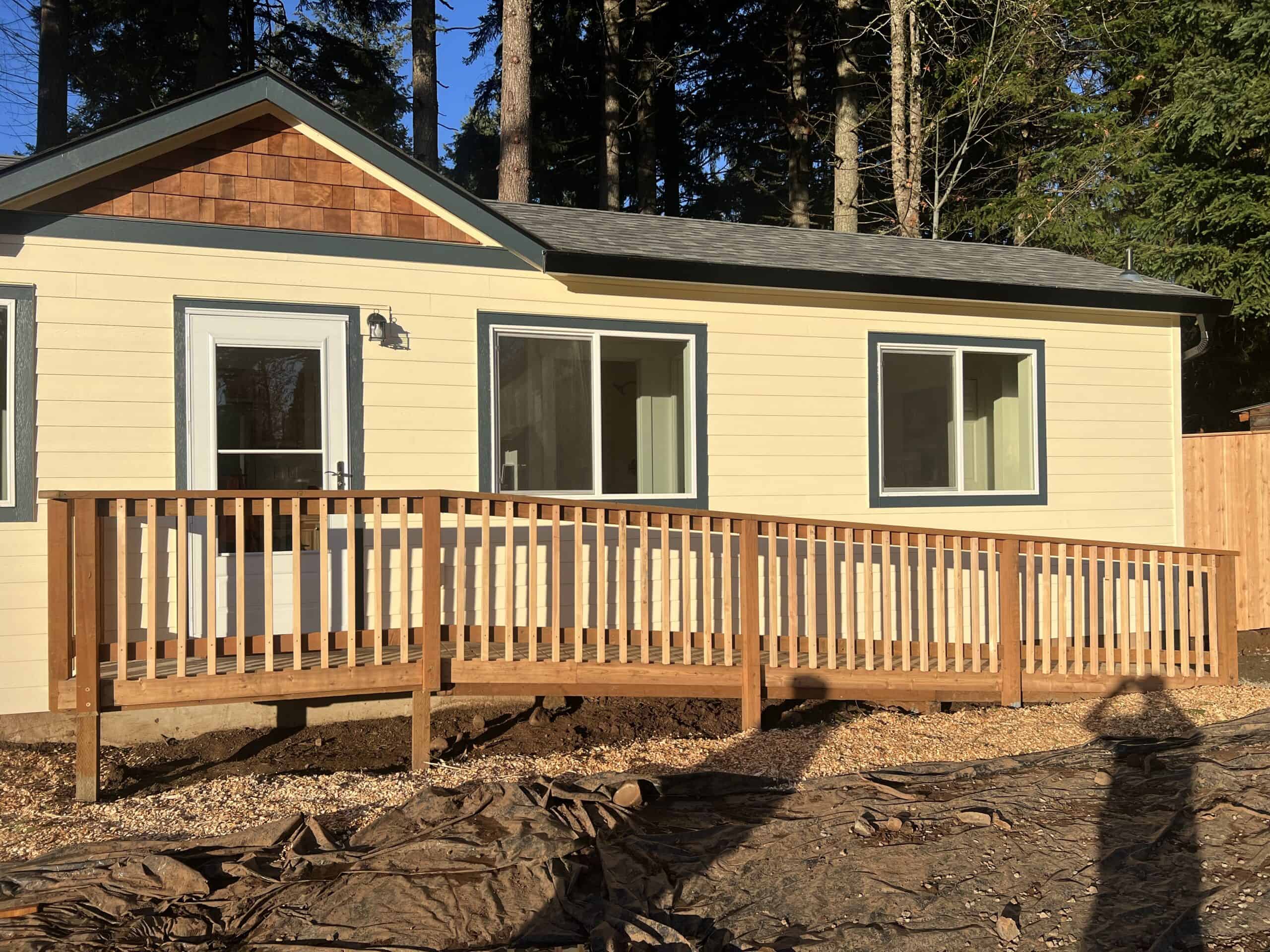 Cream and black Wolf Model K home with gable cedar shakes and ramp entry.