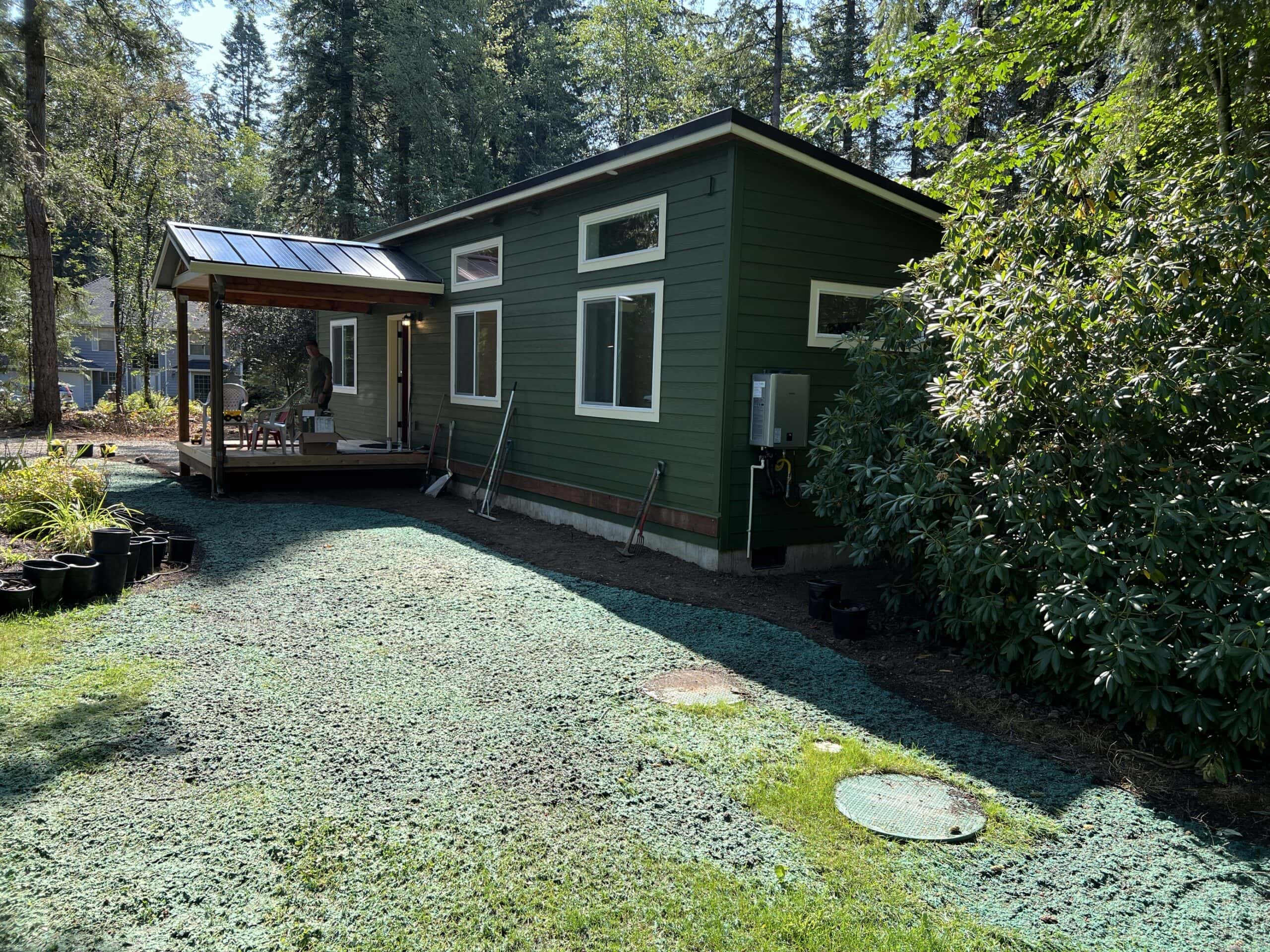 Green and white Wolf Model E home with cover front porch deck.