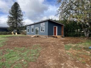 Green and white Wolf Model E home with red door.