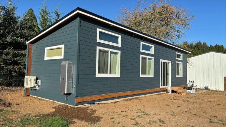 Slate blue-gray Wolf Model E home with white trim and a sliding door.