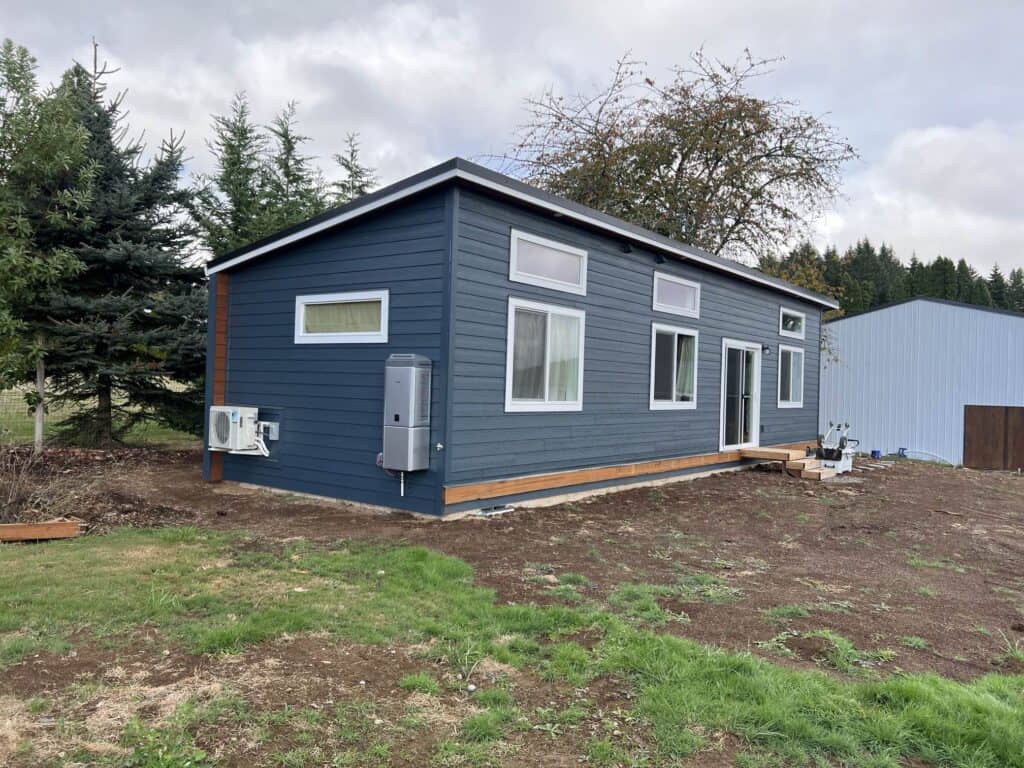 Green and white Wolf Model E home with exterior soffit lighting.