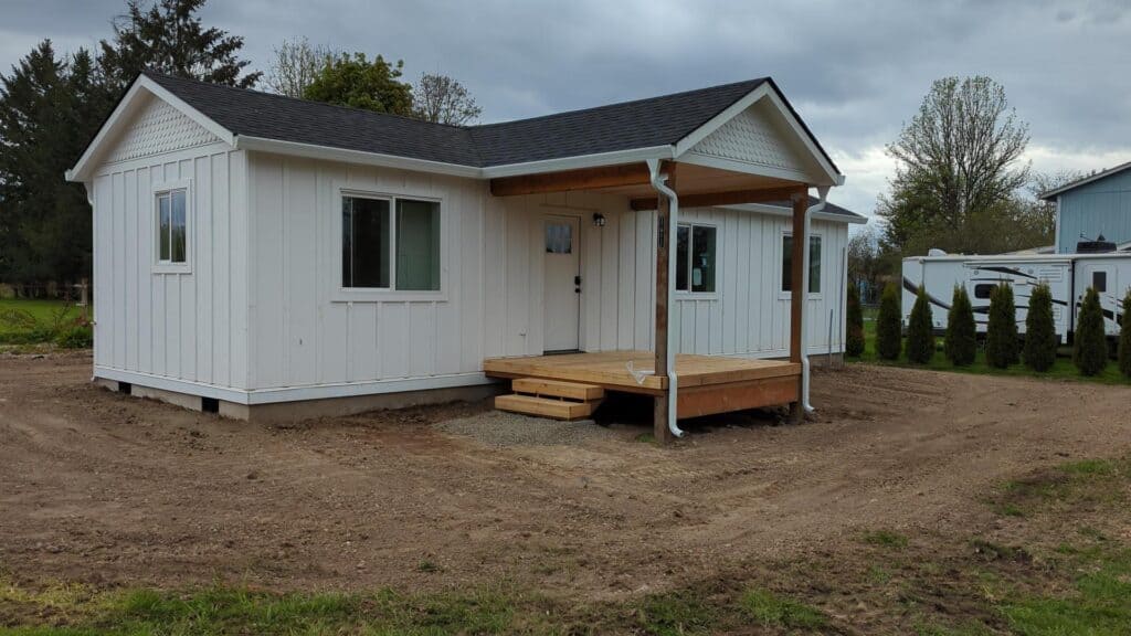 All-white Wolf Model E home with covered front deck porch.