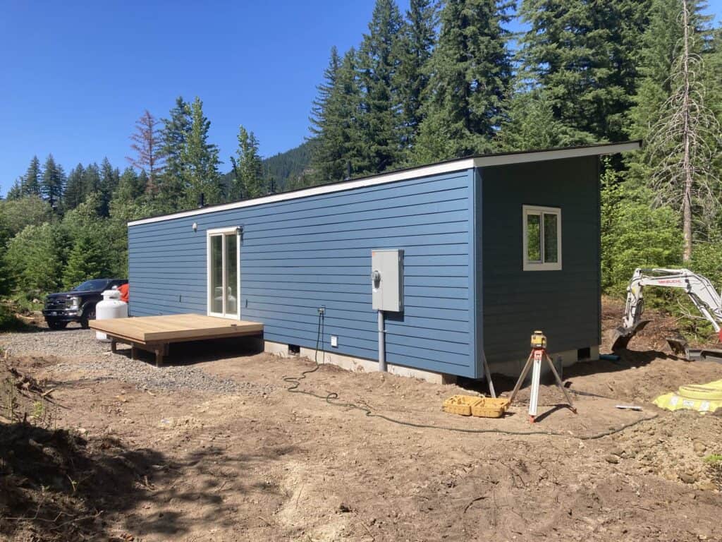 Blue and white Wolf Model E home with 8x8 deck.